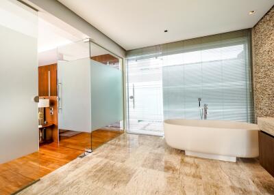 Modern bathroom with glass walls and a standalone bathtub