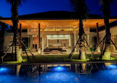 Exterior view of a modern house with a swimming pool at night