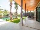 Outdoor patio next to a swimming pool with deck chairs and tropical landscaping