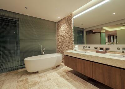 Modern bathroom with stone feature wall and large bathtub