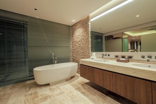 Modern bathroom with stone feature wall and large bathtub