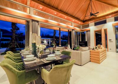 Spacious living area with dining table and couch under wooden ceiling