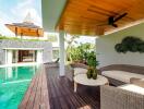 Outdoor living area adjacent to swimming pool with wicker furniture and wooden deck