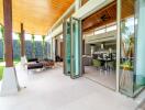 Modern open-plan living and dining area with large glass doors opening to outdoor seating