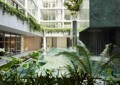 Modern apartment building with indoor pool and lush greenery