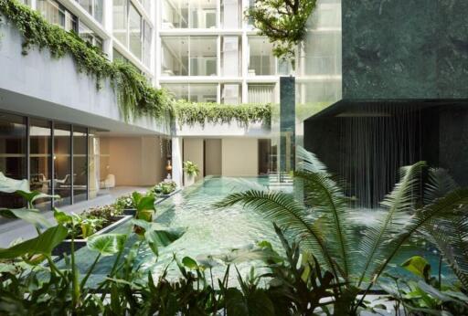 Modern apartment building with indoor pool and lush greenery