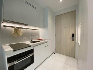 Modern compact kitchen with integrated appliances and light wood accents