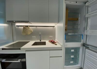 Modern kitchen with stove and open refrigerator