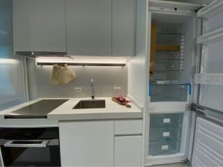 Modern kitchen with stove and open refrigerator