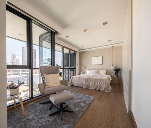 Modern bedroom with large windows and a comfortable chair