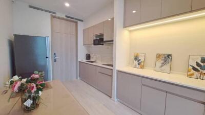 Modern kitchen with beige cabinets, integrated appliances, and decor