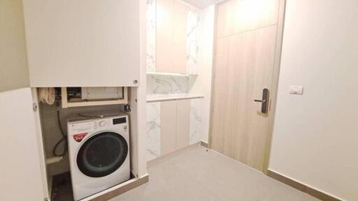 Laundry room with washing machine and storage cabinets