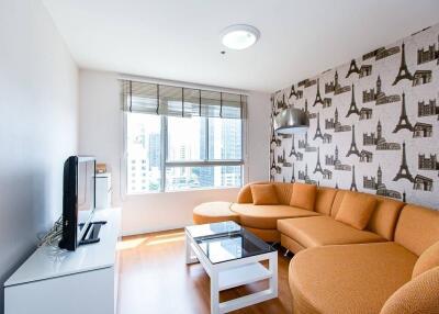 Living room with city-themed wallpaper, orange sofa, and large window