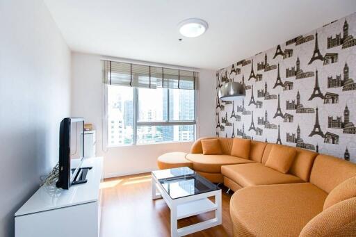 Living room with city-themed wallpaper, orange sofa, and large window