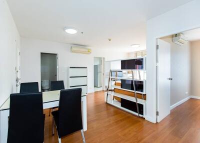 Modern dining room with table and chairs, open to living area with hardwood flooring