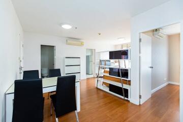 Modern dining room with table and chairs, open to living area with hardwood flooring