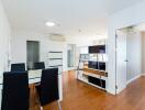 Modern dining room with table and chairs, open to living area with hardwood flooring