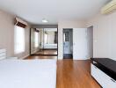 Spacious bedroom with wooden flooring, mirrored wardrobe, and air conditioning