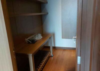 Small storage room with wooden shelves and flooring