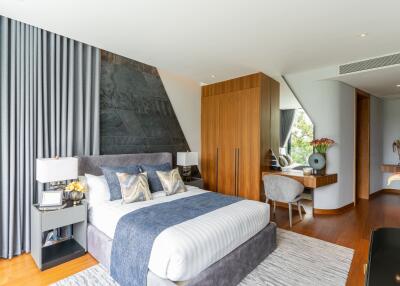 Modern bedroom with large bed, wooden floors, and ample storage