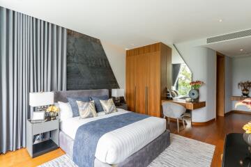 Modern bedroom with large bed, wooden floors, and ample storage