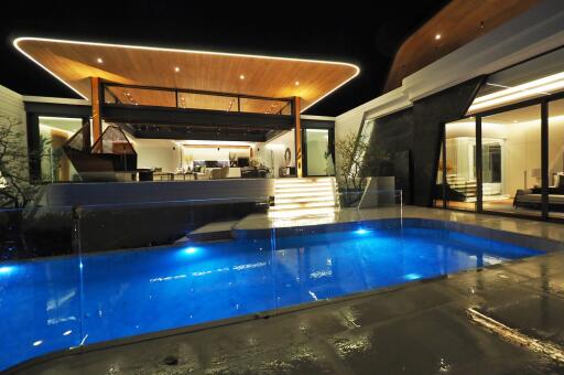 Modern house exterior with illuminated pool at night