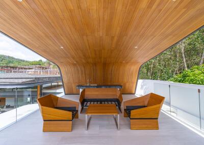 Modern outdoor seating area with wooden ceiling and comfortable chairs