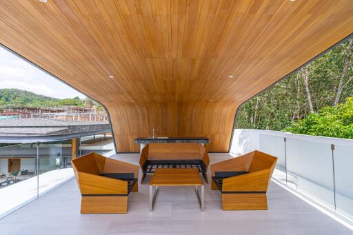 Modern outdoor seating area with wooden ceiling and comfortable chairs