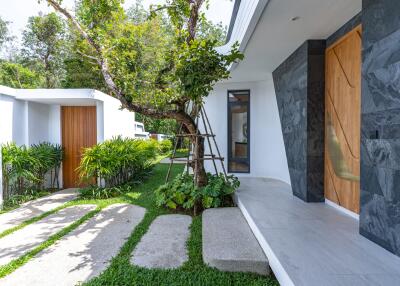 Modern exterior with lush greenery and wooden accents