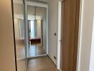 Hallway with mirrored wardrobe and wooden door