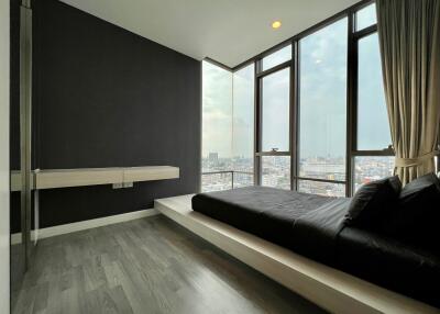 Modern bedroom with large windows and city view