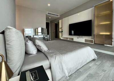 Modern bedroom with sleek furniture and flat-screen TV