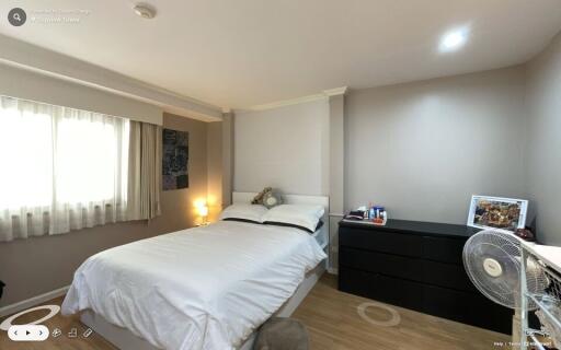 Spacious bedroom with bed, bedside table, dresser, and fan