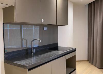 modern kitchen with grey cabinetry and black countertop