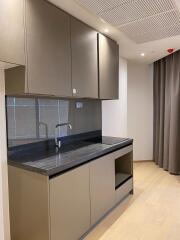 modern kitchen with grey cabinetry and black countertop