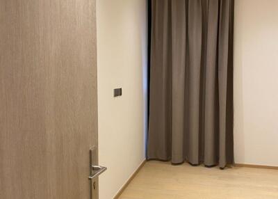 Empty bedroom with wooden flooring and curtains