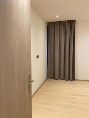 Empty bedroom with wooden flooring and curtains