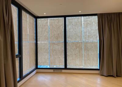 Spacious living room with large windows covered by temporary panels