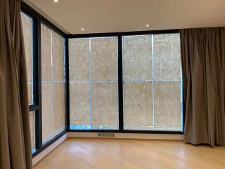 Spacious living room with large windows covered by temporary panels