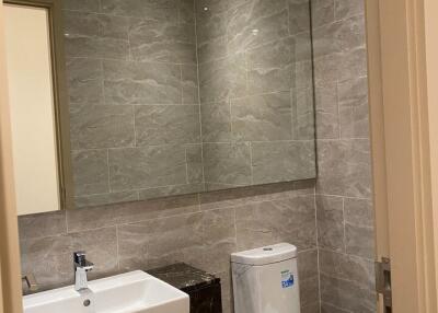 Modern bathroom with large mirror and tiled walls