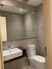 Modern bathroom with large mirror and tiled walls