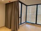 Empty room with large windows and curtains