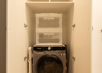 Laundry area with washing machine and storage shelves