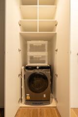 Laundry area with washing machine and storage shelves