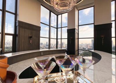 Modern bar area with panoramic city views and chandelier