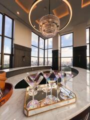 Modern bar area with panoramic city views and chandelier