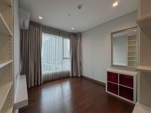 Spacious bedroom with large window and wooden floor