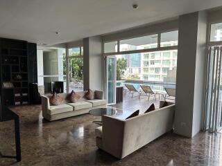 Modern living room with large windows and access to a spacious balcony