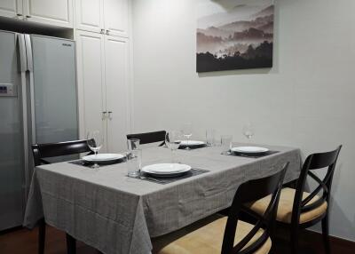 Dining room with table set for four, refrigerator, and air conditioning unit