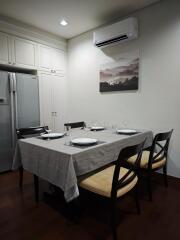 Dining room with table set for four, refrigerator, and air conditioning unit